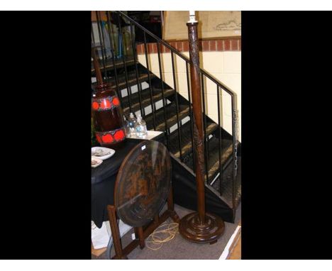 A decorative carved Malayan folding occasional table, together with a standard lamp