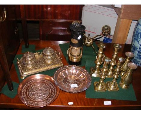A number of metal objects including candlesticks and hammered bowls, together with vintage miners lamp
