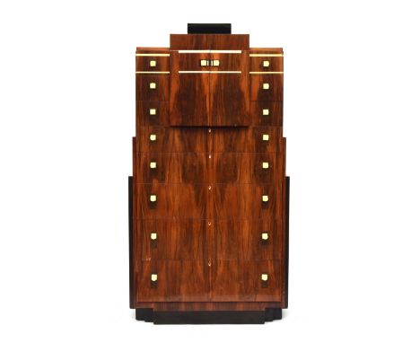 A French Art Deco maccasar ebony pedestal chest, stepped top, over a pair of cupboard doors and an arrangement of eleven grad
