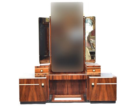 A French Art Deco maccasar ebony dressing table, triple plate mirrors, three plain frieze drawers, flanked by the stepped ped