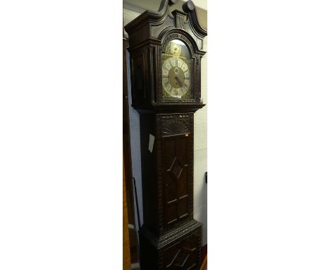 A relief carved oak longcase clock, having an arched brass and silvered dial with Westminster chime, subsidiary seconds dial,