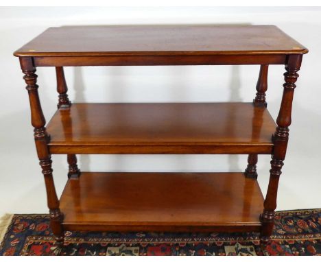 A mid-Victorian mahogany round cornered three-tier buffet, raised on turned supports to brass cup castors, width 122cm
