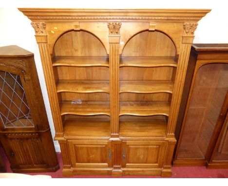 A contemporary stained hardwood Ethan Allen 'Legacy' bookcase, having twin arched open shaped shelf upper sections over reces