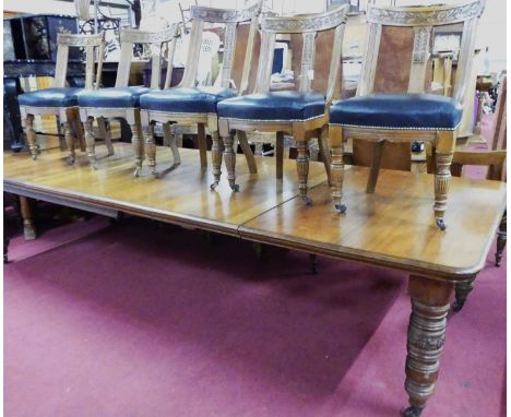 A late Victorian oak round cornered extending dining table, having a wind-out action, five extra drop-in leaves, and raised o