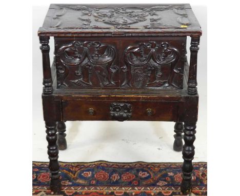 An unusual relief carved stained oak hinge top work box, with fabric lined interior and single frieze drawer, on bobbin turne