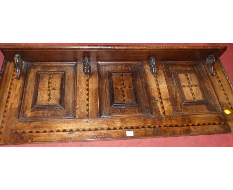 A joined oak and chequer inlaid three-panelled wall shelf, width 122cm