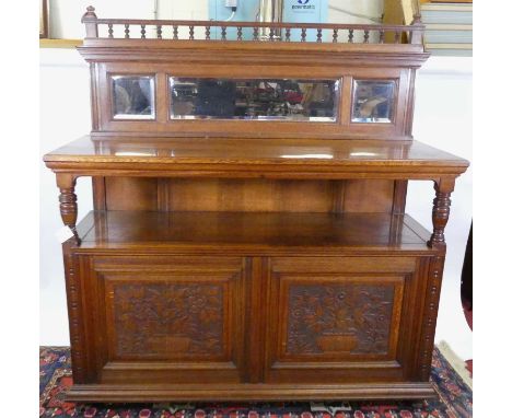 A late Victorian oak mirror back buffet, having ring turned supports over twin floral relief carved cupboard door base, width