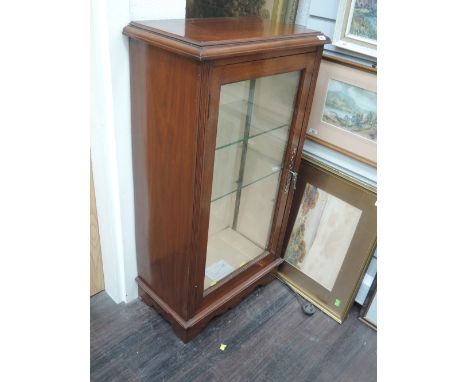 An early 20th century mahogany display cabinet having glass door and bracket base