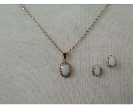 A small opal pendant in a 9ct gold collared mount with twist decoration on a 9ct gold chain with matching earrings