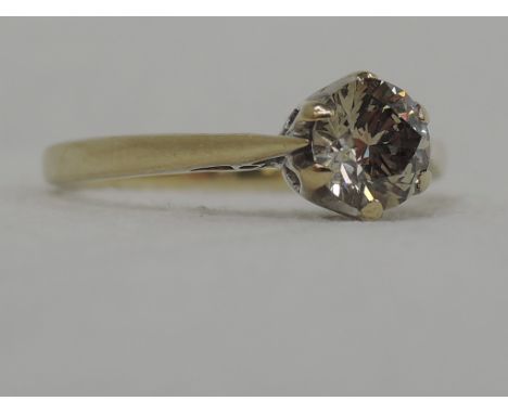 A lady's dress ring having a champagne diamond solitaire, approx .5ct in a claw mount to knife blade shoulders on a 9ct gold 