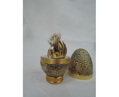 A cased Stuart Devlin 1978 silver gilt limited edition surprise Easter egg having a textured mottled exterior opening to reve