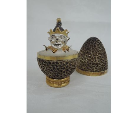 A cased Stuart Devlin 1973 silver gilt limited edition surprise Easter egg having a textured exterior opening to reveal a tre