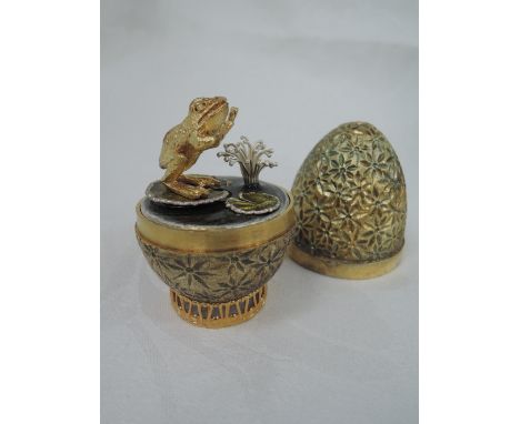 A cased Stuart Devlin 1979 silver gilt limited edition surprise Easter egg having a stylised floral textured exterior opening