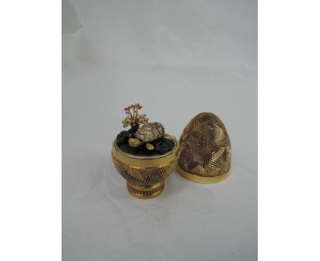 A cased Stuart Devlin 1980 silver gilt limited edition surprise Easter egg having a textured stylised brush stroke exterior o