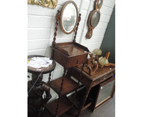 A 1920's oak shaving stand having oval toilet mirror over shelf and two tiers on twist supports