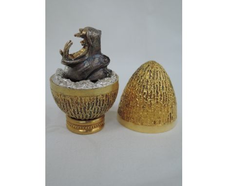 A cased Stuart Devlin 1974 silver gilt limited edition surprise Easter egg having a textured exterior opening to reveal a tre