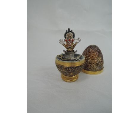 A cased Stuart Devlin 1981 silver gilt limited edition surprise Easter egg having a textured exterior opening to reveal a tre