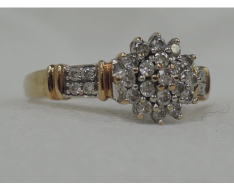 A lady's dress ring having a triple diamond cluster with band and diamond set shoulders, approx .5ct on a yellow metal loop s