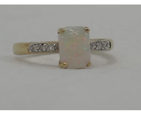 A lady's dress ring having a simulated opal in a claw set raised mount with diamond set shoulders on a 9ct gold loop,  size P