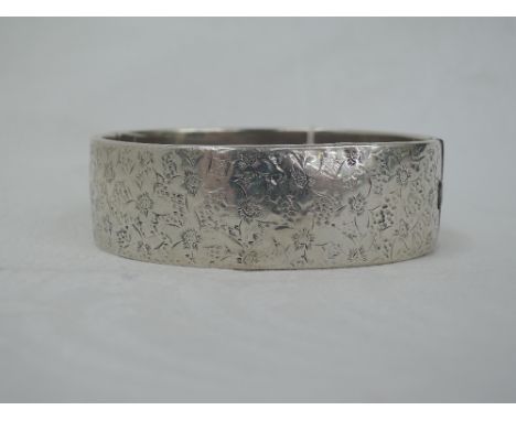 A French silver hinged bangle having engraved floral decoration