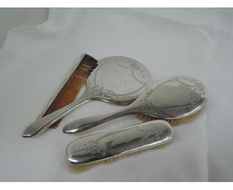 A four piece silver dressing table set having engraved swag and bow decoration,  Birmingham 1922, Williams (Birmingham) Ltd