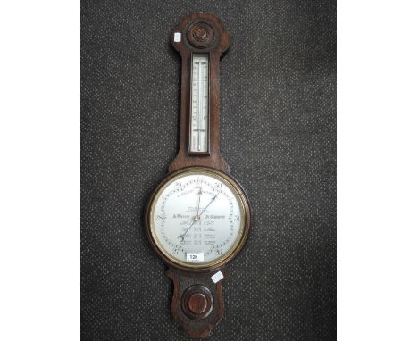 An early 20th century oak framed aneroid barometer by Wilson, having thermometer scale