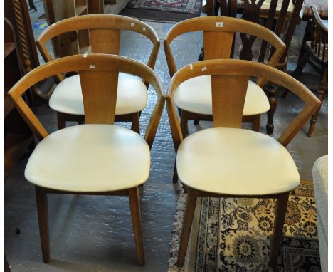 A set of four mid Century light oak curve and splat back dining chairs with leather finish seats and tapering legs by Greaves