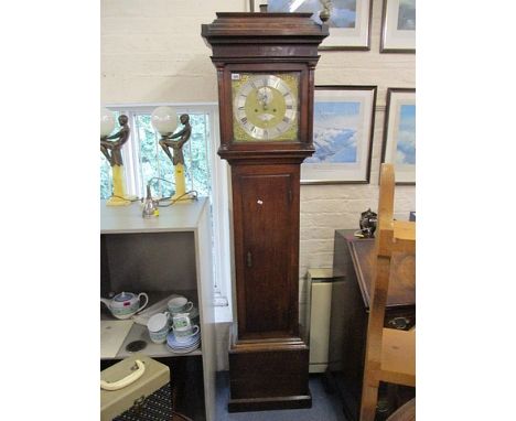 A George III oak longcase clock, the hood having turned columns, over a door and box base on a plinth, with an eight day bell