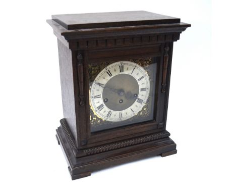 A continental oak cased eight-day mantel clock, the three train movement striking the quarters and hours on five tubular rods