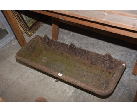 A rectangular cast iron wall mounted trough. 