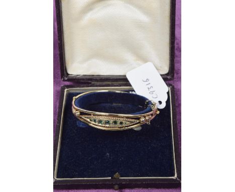 An Edwardian 9ct gold garnet topped doublet emerald and diamond bangle The circular shape green garnet topped doublet and eme