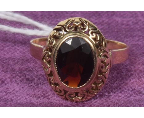 A garnet single stone ringThe oval shape garnet within an openwork surround, ring size Q, weight approx. 3.5g. 