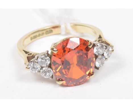 A 9ct gold paste dress ringThe oval shape orange paste with circular shape cubic zirconia sides, hallmarks for Sheffield, rin