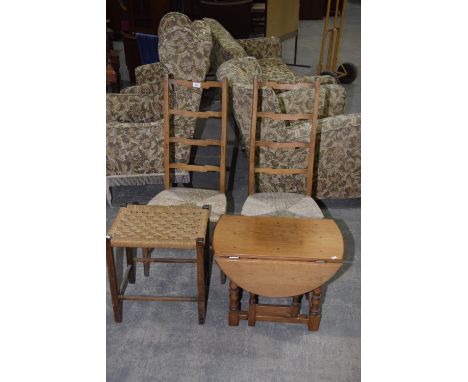 A reproduction oak drop leaf occasional table, two ladder back rush seat chairs, string top stool. (4) 