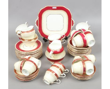 An Aynsley bone china tea service with ivory and burgundy glazes and gilt decoration including cups and saucers, milk jug, su