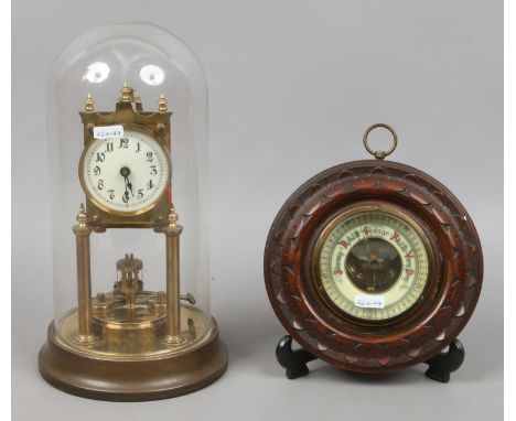 A brass torsion clock under glass dome along with a carved oak wall barometer.