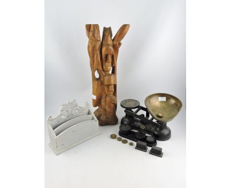 A carved painted wood letter rack, a carved African figural group and a set of scales with weights.