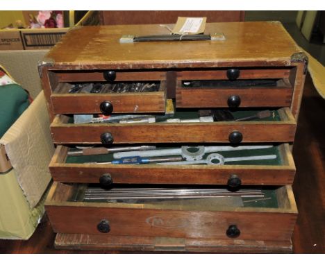 An early 20th century Moore & Wright oak seven-drawer tool box, containing a quantity of engineering tools, including a cased