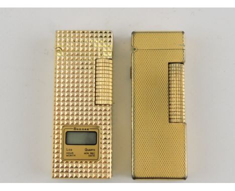 A Dunhill gold plated rollagas cigarette lighter, with a plain engine turned body, together with a similar Sunnex example inc