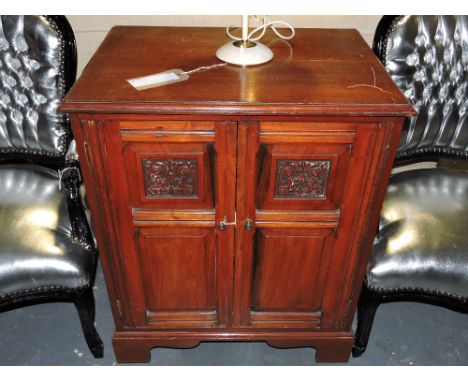 An Edwardian walnut side cabinet, the rectangular moulded top above an arrangement of carved panel doors, on shaped bracket f