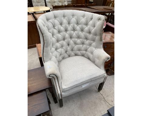 A BUTTON AND WING BACK ARMCHAIR 