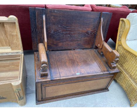 AN OAK MONK'S BENCH WITH LOWER COMPARTMENT AND LION SHAPED ARMRESTS - CONVERTS TO A TABLE 