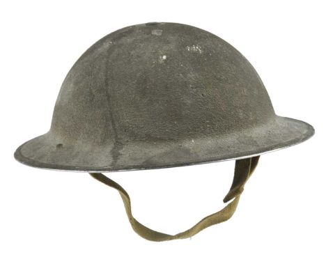 A British brodie pattern steel helmet, olive green with sand-textured finish, painted formation sign of a diamond divided red