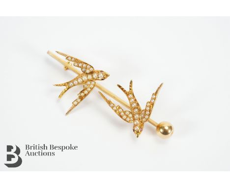 An 14-15ct yellow gold and seed pearl swallow brooch on 9ct gold pin, measures approx. 60mm x 20mm. Swallows set with seed pe