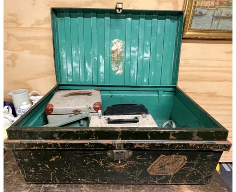 A metal trunk containing a group of mixed photography and film equipment.