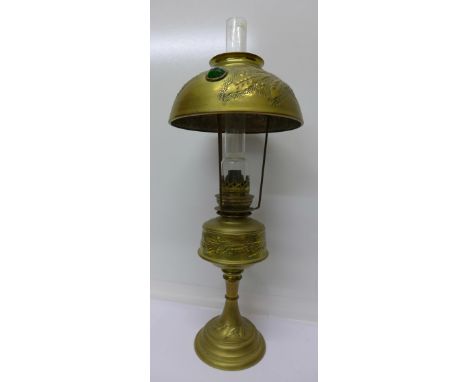 A brass oil lamp and brass shade with blue, green and red faceted lights, height 52cm