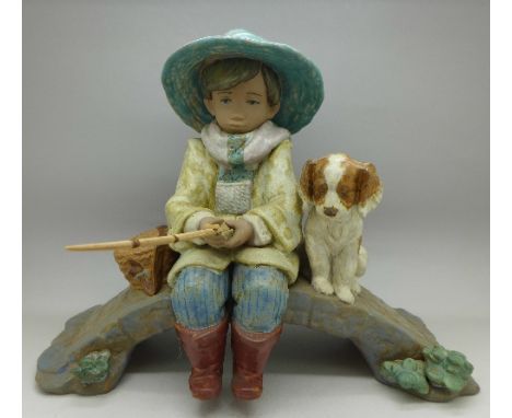 A coloured Lladro figure of a boy fishing with a dog, 2237, The Old Fishing Hole, height 23cm