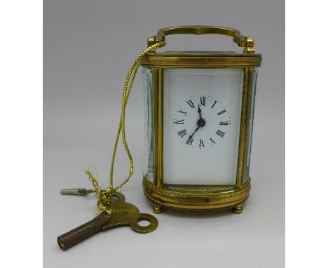 A brass and glass oval cased carriage clock