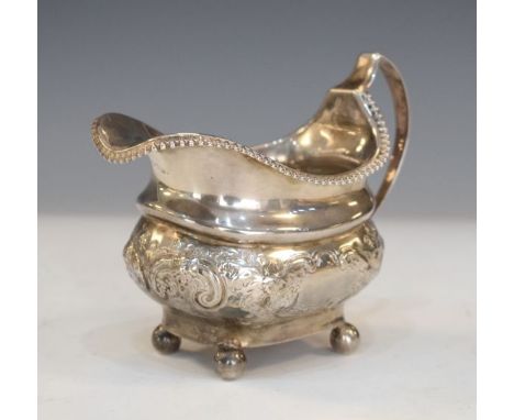 George III silver helmet shaped cream jug having embossed decoration and standing on ball feet, London 1813, 4.9oz approx   C