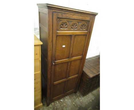 Good quality reproduction oak hall wardrobe with a single carved and panel door 